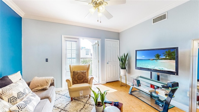 living area featuring ornamental molding, visible vents, light wood-style flooring, and a ceiling fan