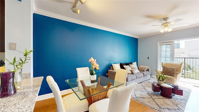 living area with crown molding, baseboards, a ceiling fan, and wood finished floors