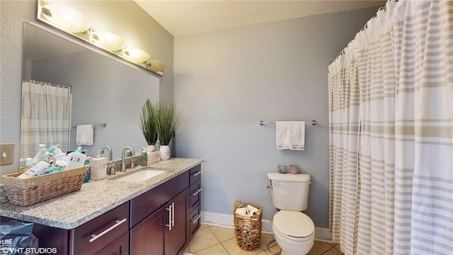 full bathroom featuring toilet, tile patterned floors, vanity, and baseboards