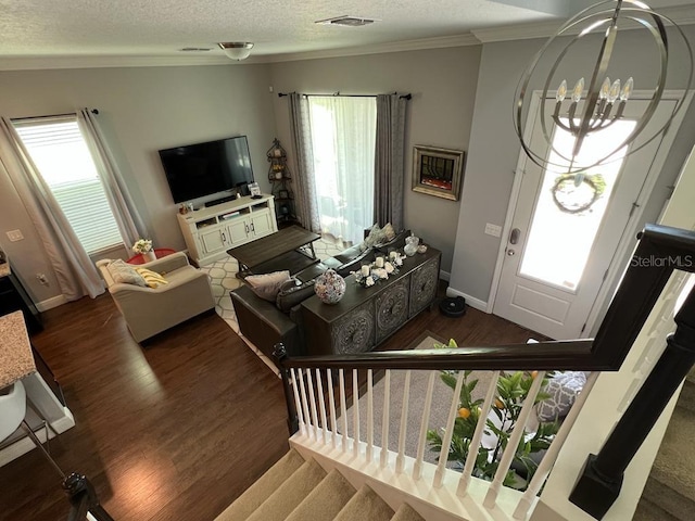 entryway featuring a textured ceiling, wood finished floors, a wealth of natural light, and stairs