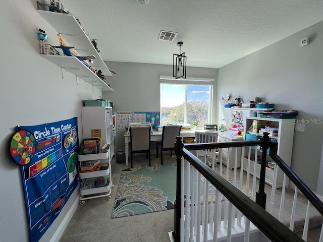 carpeted office space featuring visible vents, a textured ceiling, and baseboards
