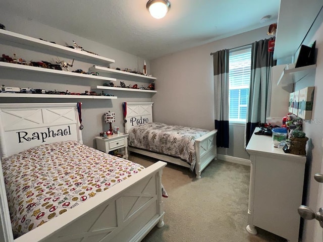 bedroom featuring light colored carpet and baseboards