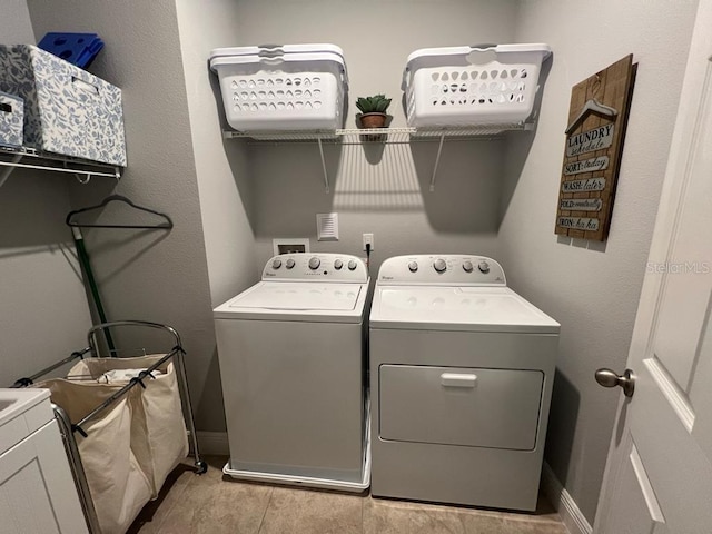 laundry area featuring baseboards, washing machine and dryer, and laundry area
