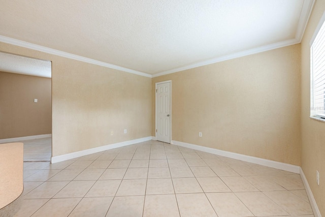 empty room featuring baseboards, ornamental molding, and light tile patterned floors