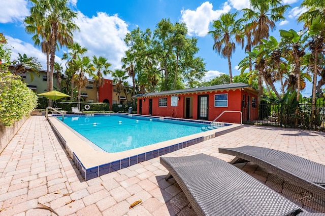pool featuring fence and a patio area