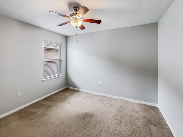 spare room with baseboards, a ceiling fan, and carpet floors