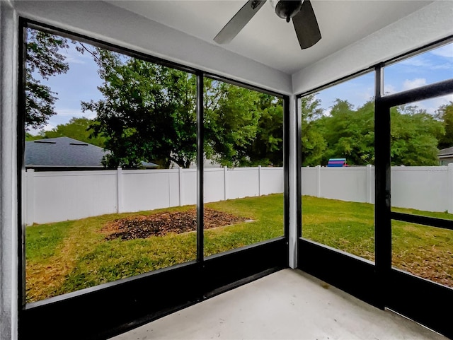unfurnished sunroom with ceiling fan