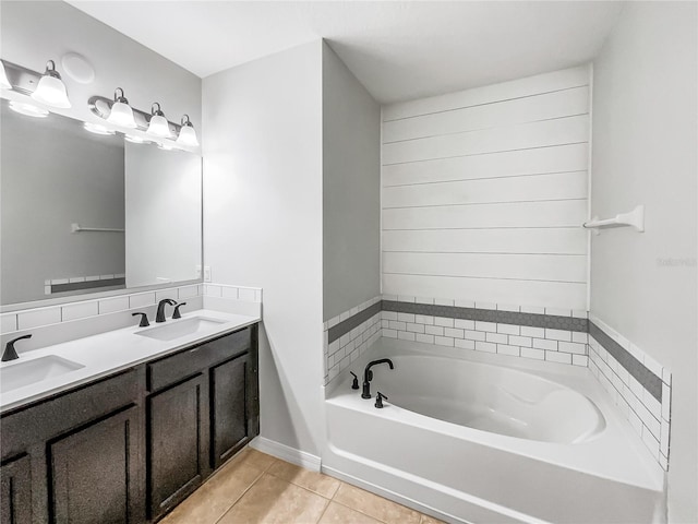 bathroom featuring tile patterned floors, double vanity, a garden tub, and a sink