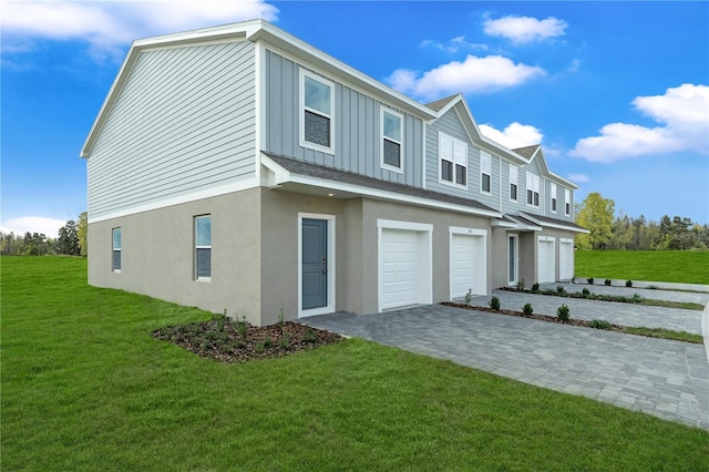 1419 Fan Palm Dr, Davenport, FL 33897 - view of side of property with a garage, decorative driveway, a yard, and board and batten siding