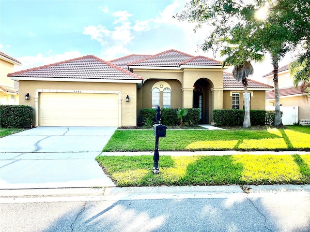 9046 Tuscan Valley Pl, Orlando, FL 32825 - mediterranean / spanish-style home featuring stucco siding, a front yard, a tile roof, an attached garage, and driveway