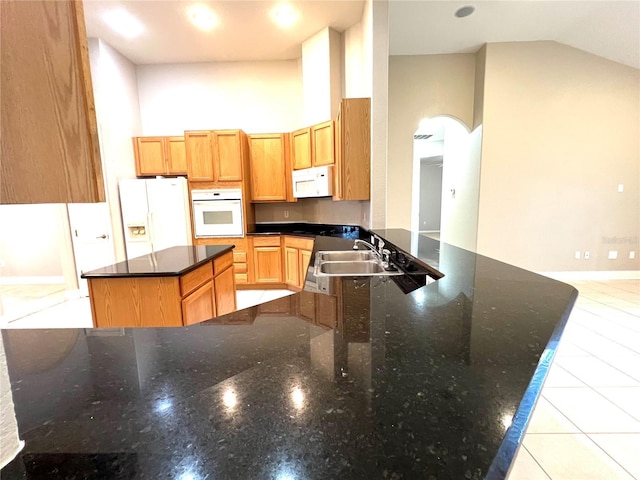 9046 Tuscan Valley Pl, Orlando, FL 32825 - kitchen with a center island, a sink, white appliances, a peninsula, and dark stone counters
