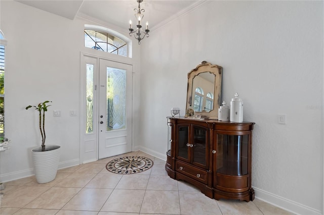 foyer entrance with baseboards, a chandelier, and light tile patterned flooring