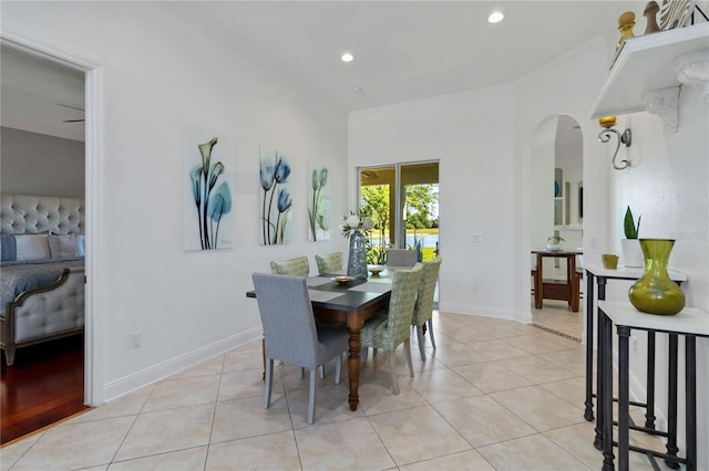 dining room featuring recessed lighting, arched walkways, ornamental molding, and light tile patterned floors