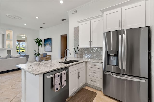 kitchen with visible vents, light tile patterned floors, a sink, a peninsula, and appliances with stainless steel finishes