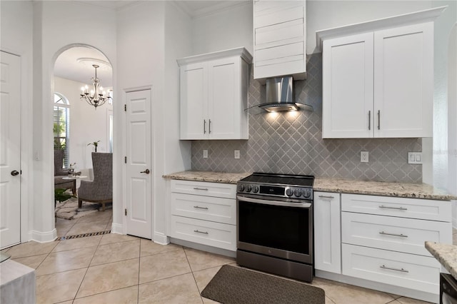 kitchen featuring arched walkways, light stone countertops, crown molding, stainless steel range with electric stovetop, and white cabinetry