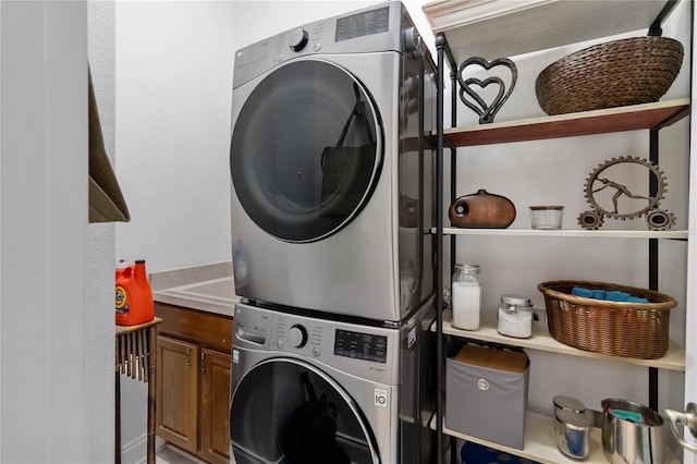 washroom featuring cabinet space and stacked washer and dryer