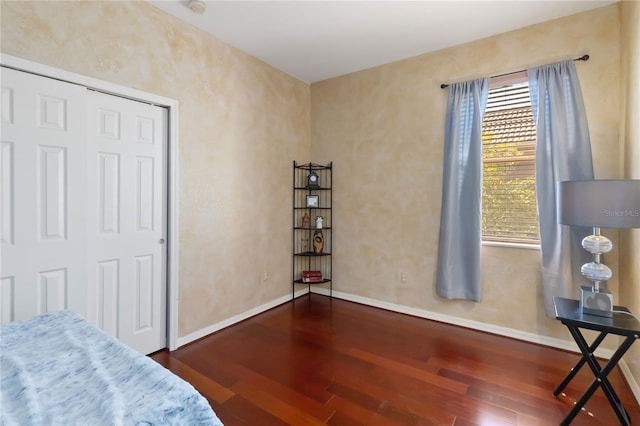 bedroom featuring dark wood finished floors and baseboards