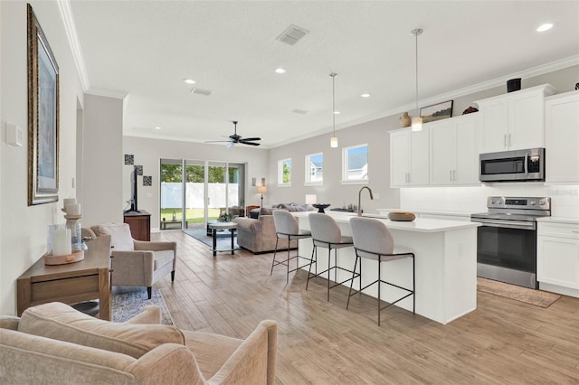 1821 Simonton Ave, Orlando, FL 32806 - kitchen with ornamental molding, open floor plan, appliances with stainless steel finishes, and visible vents