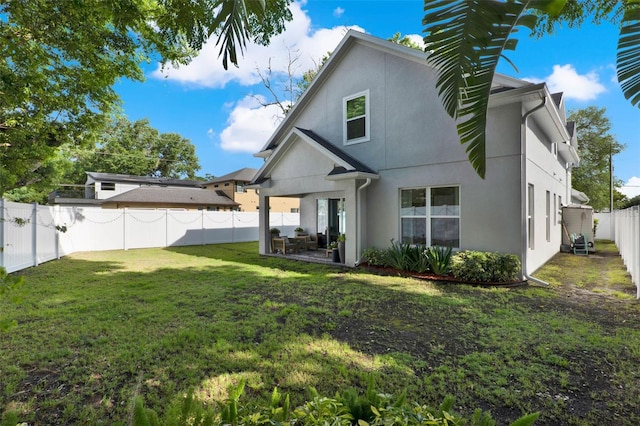 1821 Simonton Ave, Orlando, FL 32806 - back of property with a fenced backyard, stucco siding, and a lawn