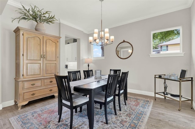 1821 Simonton Ave, Orlando, FL 32806 - dining area featuring light wood-style floors, baseboards, an inviting chandelier, and ornamental molding