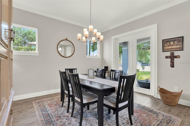 1821 Simonton Ave, Orlando, FL 32806 - dining room with wood finished floors, a healthy amount of sunlight, and a notable chandelier