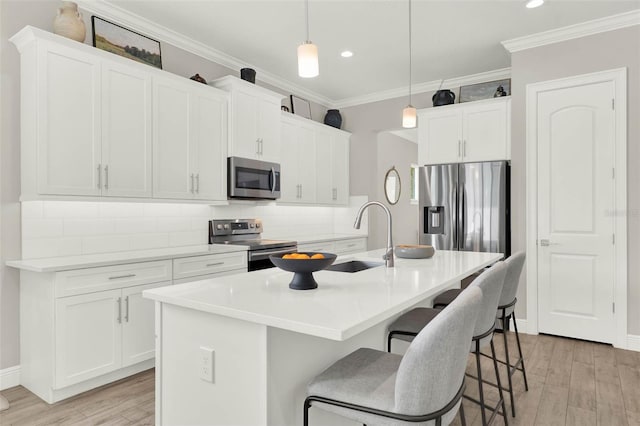1821 Simonton Ave, Orlando, FL 32806 - kitchen featuring light wood finished floors, stainless steel appliances, a kitchen breakfast bar, a sink, and backsplash