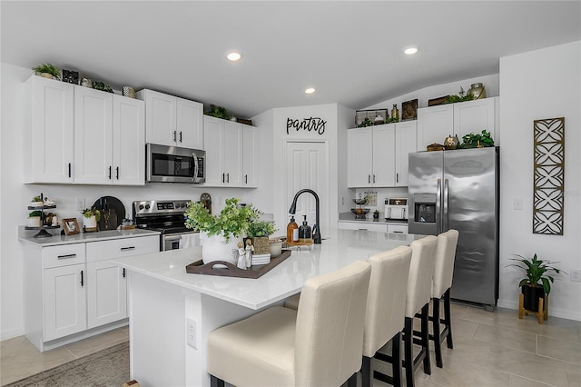 4094 San Clemente Ct, North Fort Myers, FL 33917 - kitchen featuring white cabinets, appliances with stainless steel finishes, and a kitchen bar