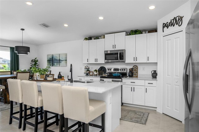 4094 San Clemente Ct, North Fort Myers, FL 33917 - kitchen with an island with sink, visible vents, appliances with stainless steel finishes, light countertops, and a sink
