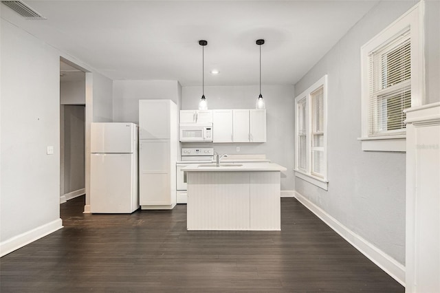 kitchen featuring white appliances, a kitchen island with sink, light countertops, baseboards, and visible vents