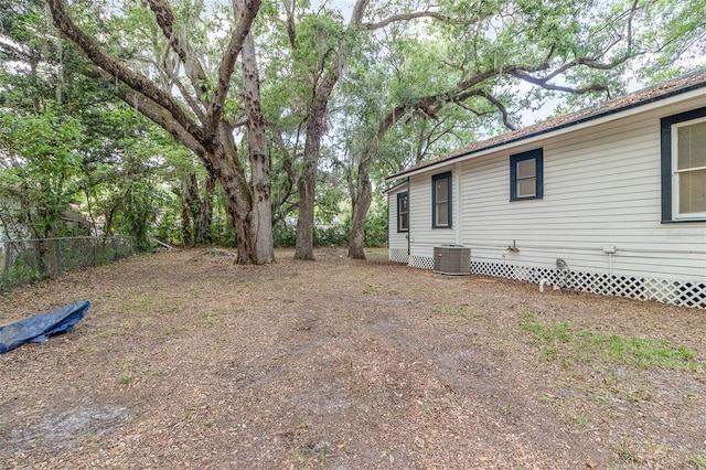 view of yard with fence and central AC unit