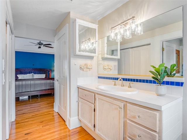 811 Laurel Ave, Orlando, FL 32803 - ensuite bathroom featuring wood finished floors, vanity, ceiling fan, decorative backsplash, and a chandelier
