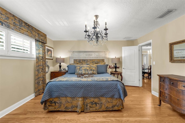 3015 Dawley Ave, Orlando, FL 32806 - bedroom featuring wood finished floors, a chandelier, and a textured ceiling