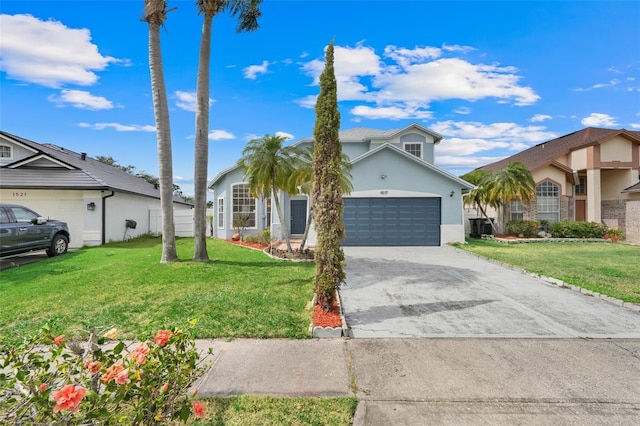 1517 Abberton Dr, Orlando, FL 32837 - view of front facade featuring an attached garage, concrete driveway, stucco siding, and a front lawn