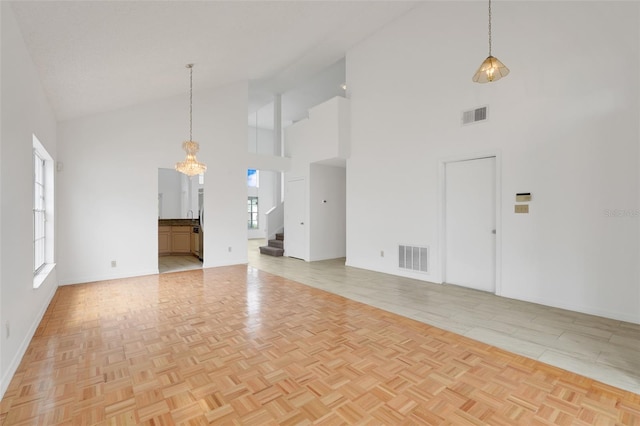 1517 Abberton Dr, Orlando, FL 32837 - unfurnished living room featuring visible vents, high vaulted ceiling, stairway, and a chandelier