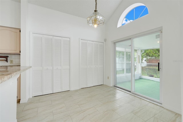 1517 Abberton Dr, Orlando, FL 32837 - unfurnished dining area with high vaulted ceiling and an inviting chandelier