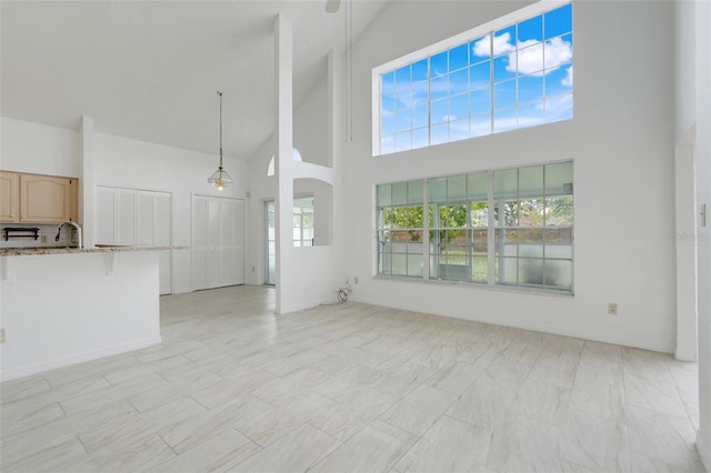1517 Abberton Dr, Orlando, FL 32837 - unfurnished living room with high vaulted ceiling, baseboards, and a sink