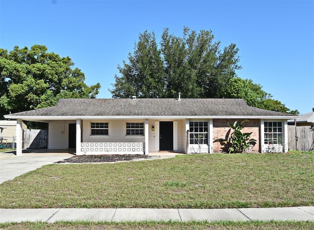 ranch-style house with a carport, driveway, a front yard, and fence