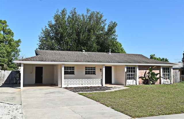 single story home featuring a front yard, fence, an attached carport, and concrete driveway