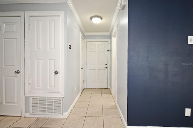 hallway featuring ornamental molding, light tile patterned floors, baseboards, and visible vents