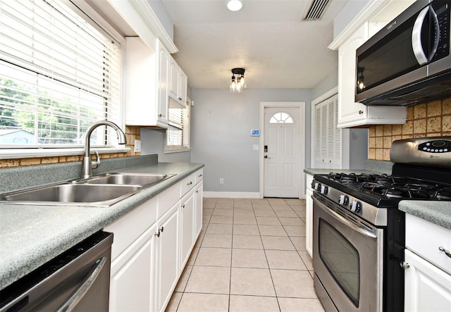 kitchen featuring light tile patterned floors, white cabinets, visible vents, appliances with stainless steel finishes, and a sink