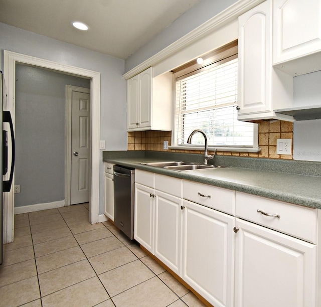 kitchen featuring stainless steel dishwasher, a sink, white cabinets, and dark countertops