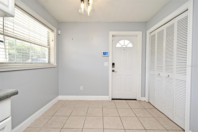 foyer entrance featuring light tile patterned floors and baseboards
