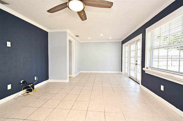 spare room with light tile patterned floors, a ceiling fan, ornamental molding, visible vents, and baseboards