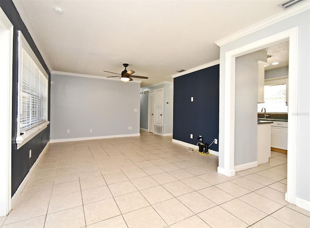 empty room with ceiling fan, baseboards, ornamental molding, and light tile patterned floors
