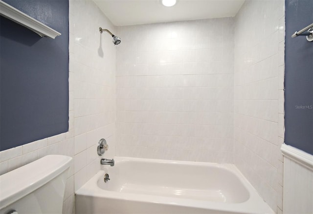 full bathroom featuring toilet, shower / bathing tub combination, and wainscoting
