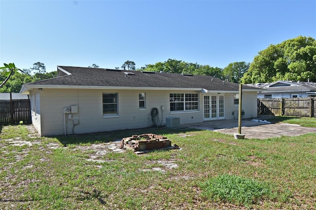 back of property featuring roof with shingles, french doors, a patio area, a fenced backyard, and a yard