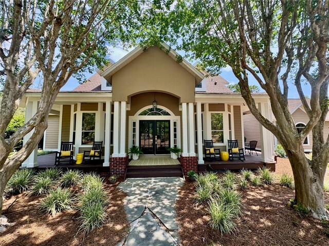 6037 Lake Erie Rd, Groveland, FL 34736 - property entrance with a porch, french doors, and a shingled roof