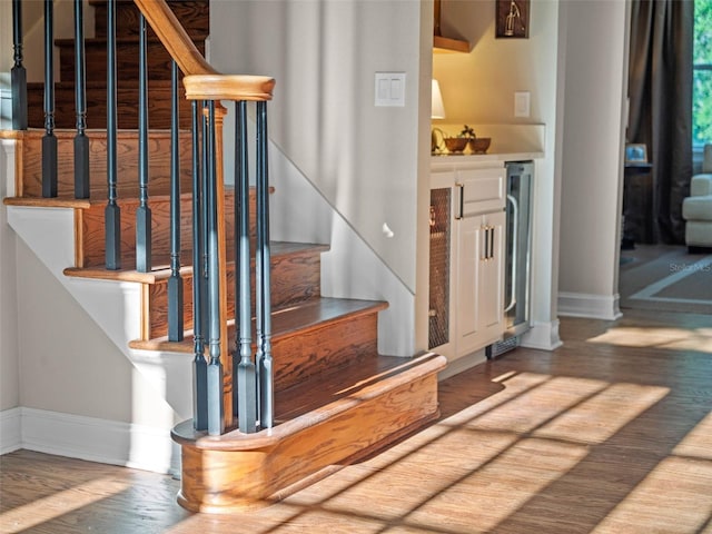 6037 Lake Erie Rd, Groveland, FL 34736 - staircase with baseboards, wood finished floors, and wine cooler