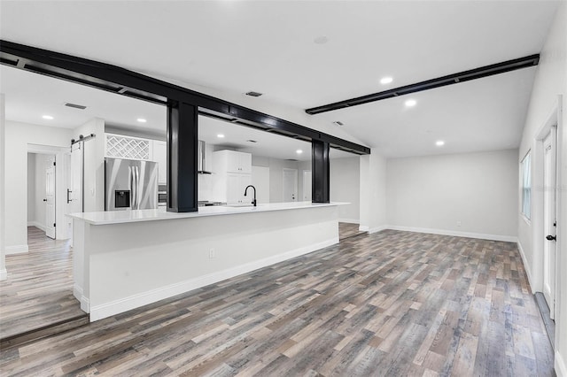 505 Lake Shore Dr, Maitland, FL 32751 - unfurnished living room featuring a barn door, light wood-style flooring, recessed lighting, and a sink