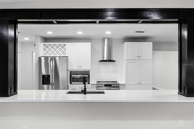 505 Lake Shore Dr, Maitland, FL 32751 - kitchen featuring light countertops, wall chimney exhaust hood, white cabinetry, and stainless steel appliances